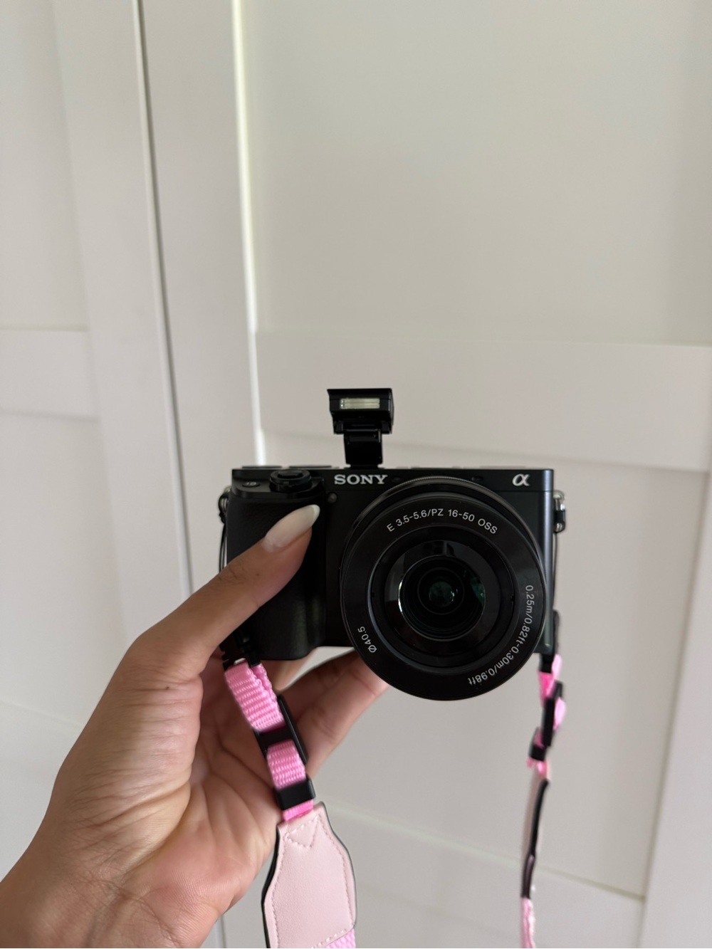 Sony Alpha a6100 APS-C Mirrorless Camera in Black with Pink Strap